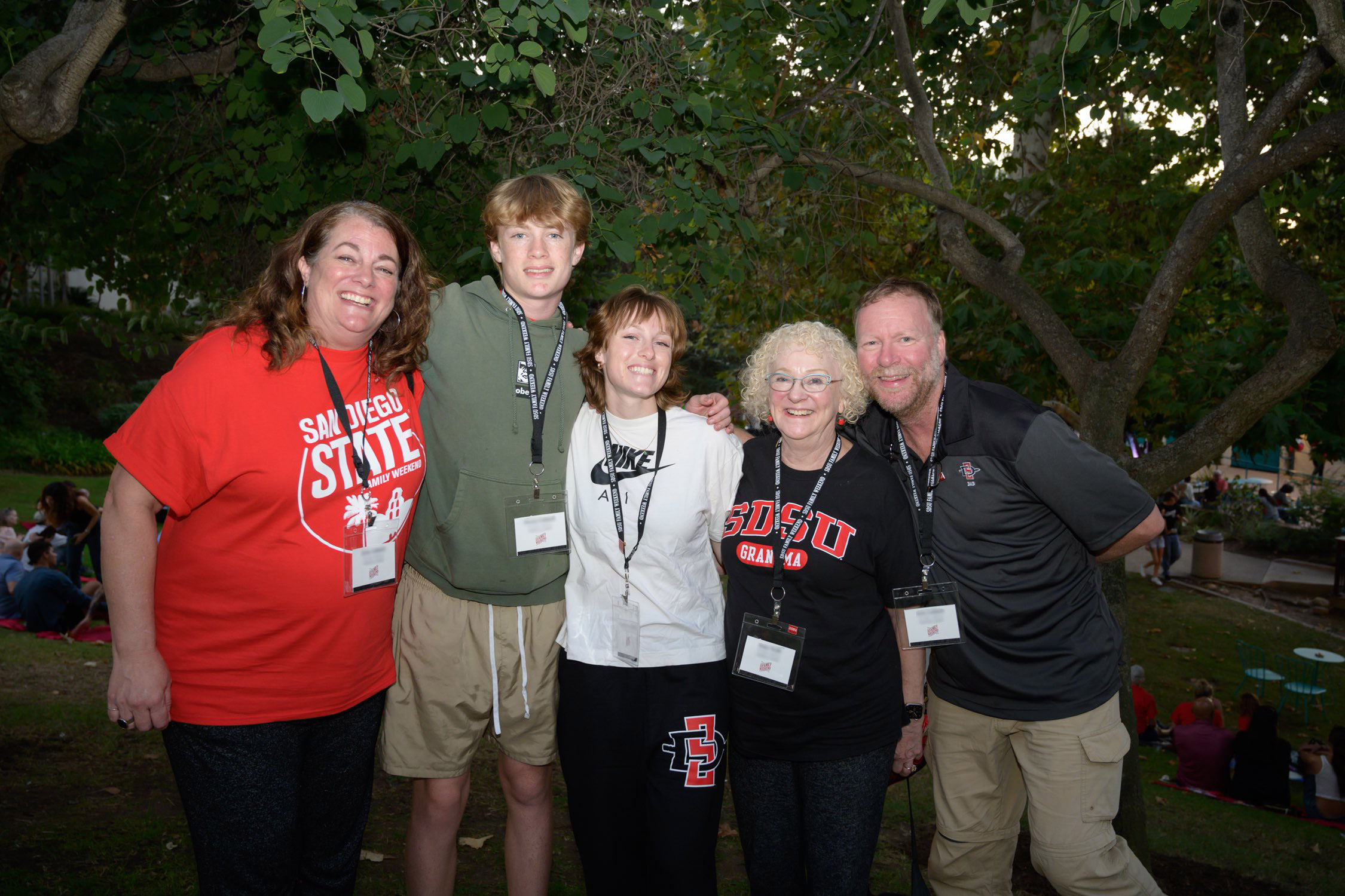 family in red and foam finger and cheering with pom pom